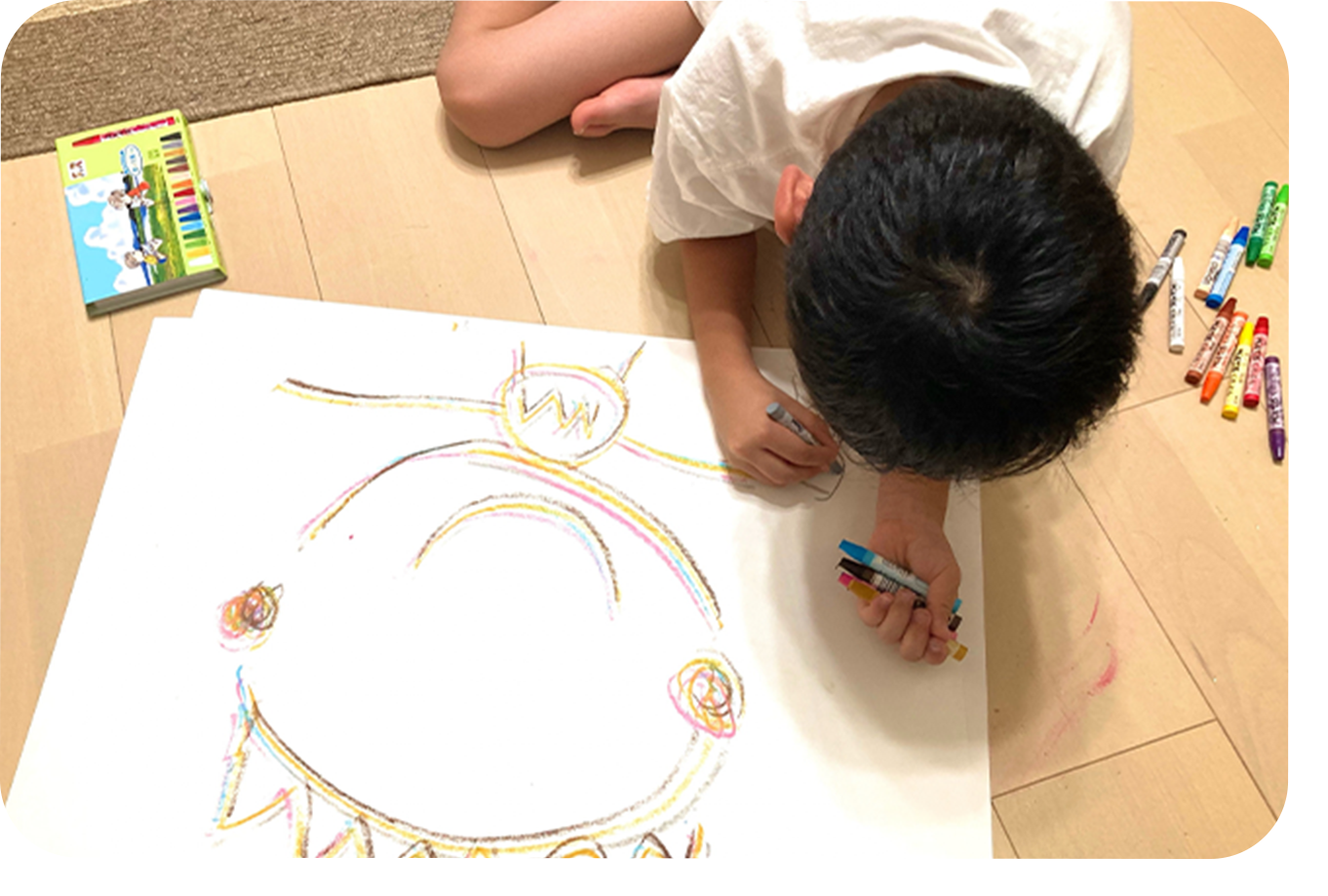 クレヨンで絵を描く園児