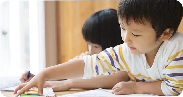 机に向かって学ぶ園児